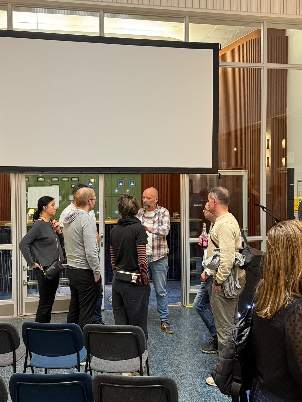 Attendees in conversation with Matthias Lübken after the talk at KI Summit Bonn